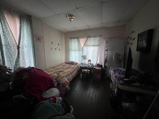 bedroom featuring hardwood / wood-style floors and a drop ceiling