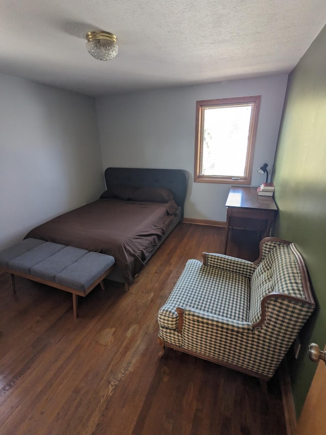 bedroom featuring a textured ceiling and wood finished floors