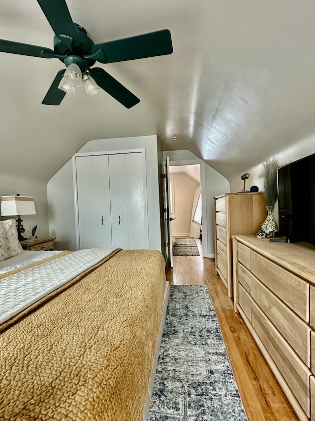 bedroom with light wood-style flooring, a ceiling fan, and lofted ceiling