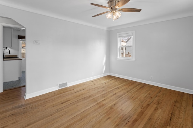 spare room featuring visible vents, baseboards, ceiling fan, and light wood-style flooring