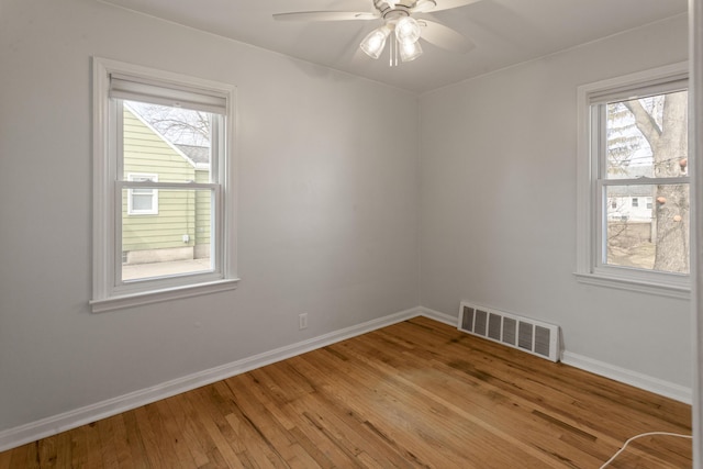 empty room with visible vents, baseboards, light wood-style floors, and a ceiling fan