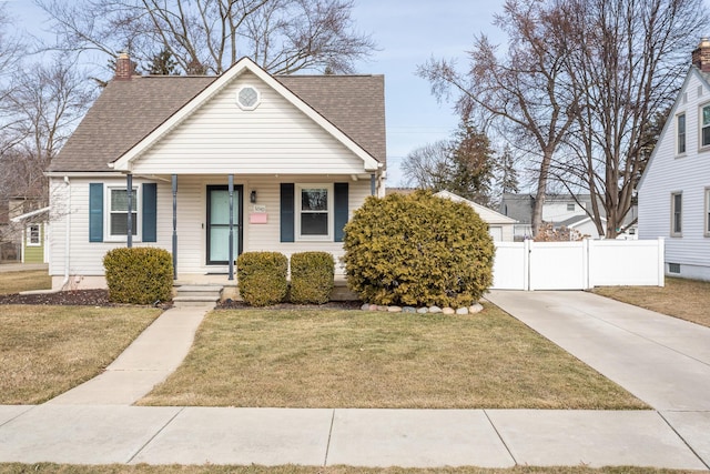 bungalow featuring a front lawn, fence, roof with shingles, and a chimney