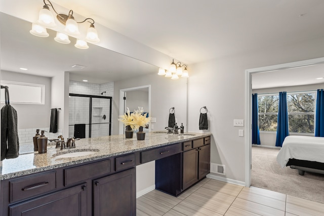 full bath featuring visible vents, a sink, an inviting chandelier, a shower stall, and double vanity