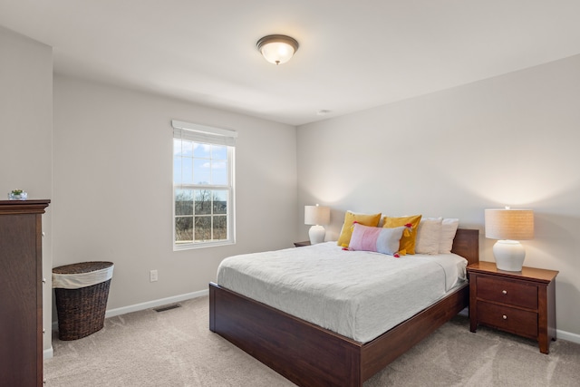 bedroom with baseboards, light carpet, and visible vents