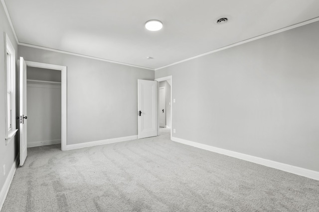 unfurnished bedroom featuring visible vents, ornamental molding, a closet, carpet flooring, and baseboards