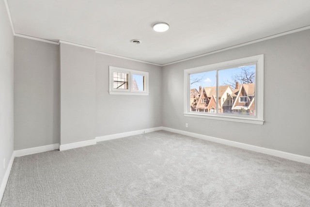 unfurnished room with visible vents, carpet floors, baseboards, and crown molding