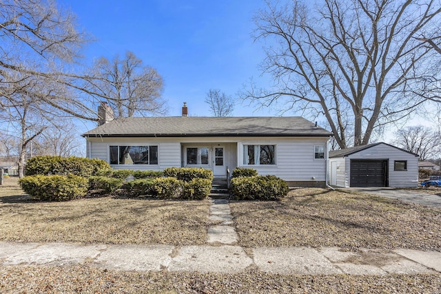 view of front of home featuring a garage, a chimney, an outdoor structure, and concrete driveway