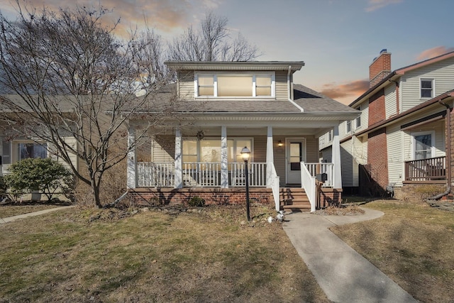 view of front of house featuring covered porch and a shingled roof