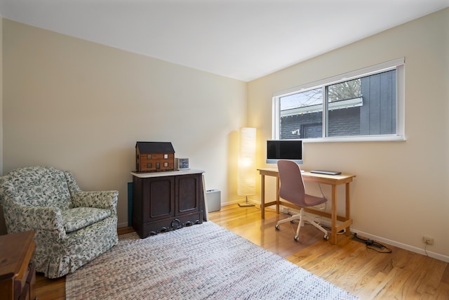 office space with baseboards and wood finished floors