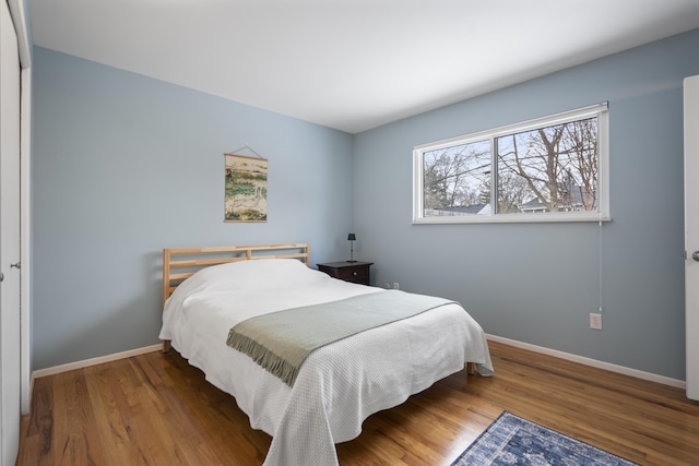 bedroom with wood finished floors and baseboards