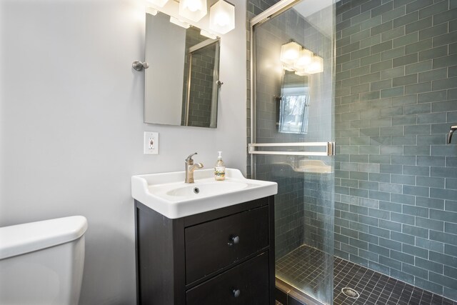 full bathroom with a shower stall, toilet, and vanity