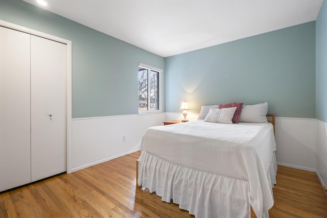 bedroom featuring wood finished floors, baseboards, and a closet