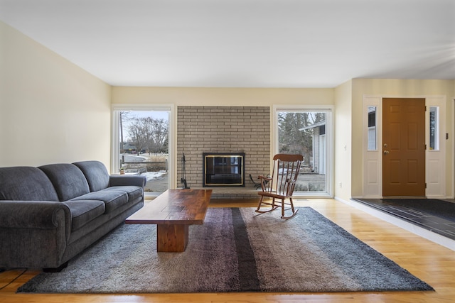 living area featuring a fireplace, wood finished floors, and baseboards