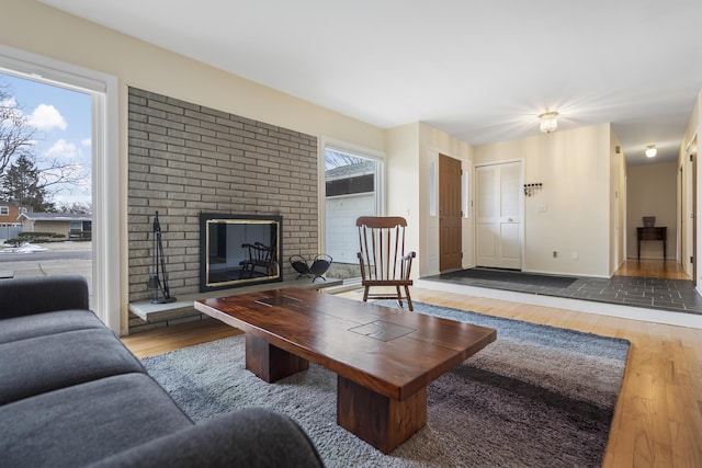 living room with baseboards, a healthy amount of sunlight, wood finished floors, and a fireplace