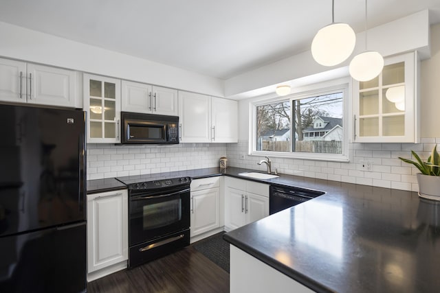 kitchen with black appliances, a sink, dark countertops, white cabinets, and glass insert cabinets