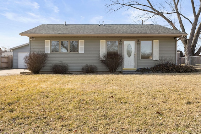 single story home featuring roof with shingles, a front yard, and fence