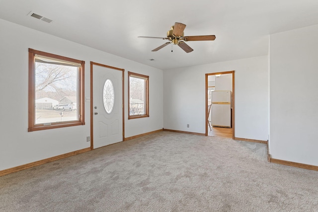 entrance foyer with light carpet, visible vents, ceiling fan, and baseboards