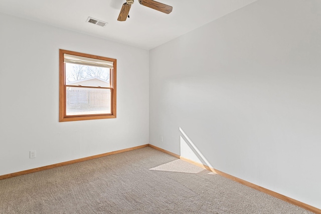 carpeted spare room featuring visible vents, baseboards, and a ceiling fan