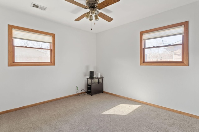 spare room with ceiling fan, carpet, visible vents, and baseboards