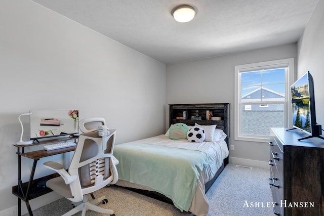 bedroom with baseboards and light carpet