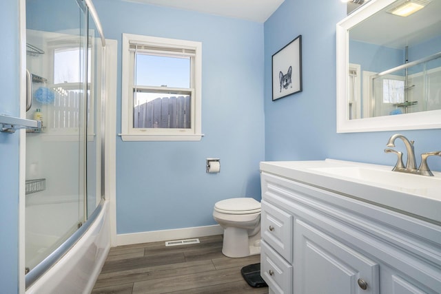 full bathroom featuring vanity, wood finished floors, visible vents, baseboards, and toilet