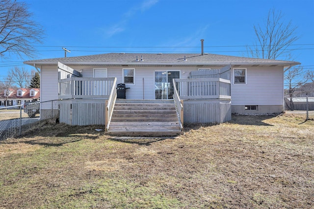 back of property featuring a wooden deck, a yard, and fence