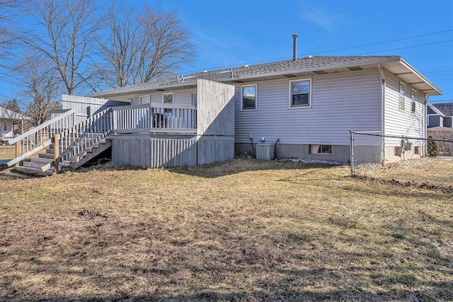 back of property featuring a lawn, a deck, fence, stairway, and cooling unit