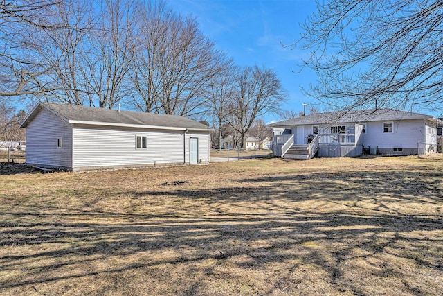 exterior space with an outbuilding, a lawn, and fence