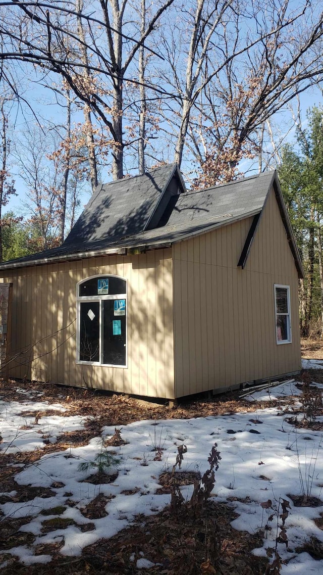 view of side of home featuring roof with shingles