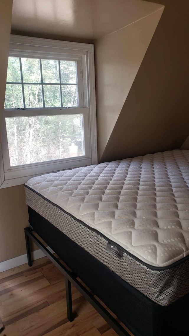 bedroom featuring baseboards and wood finished floors