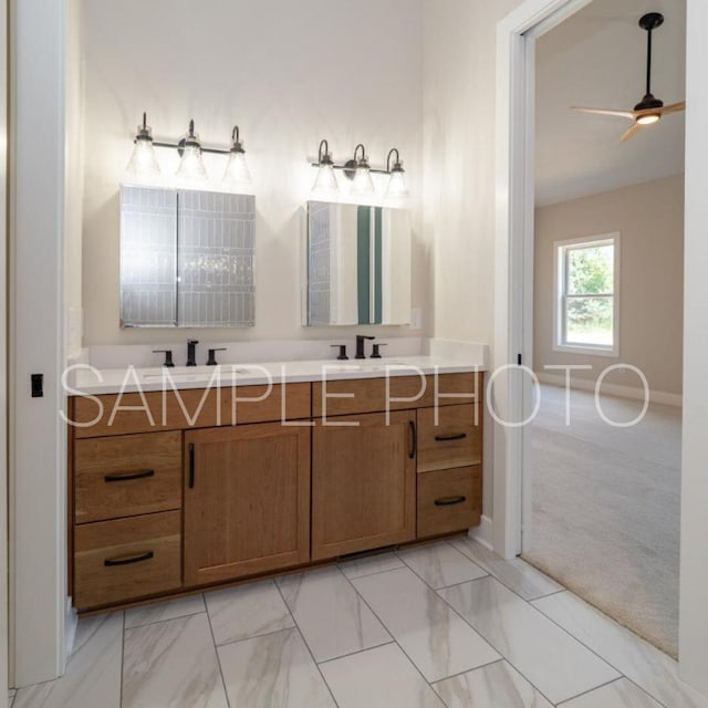 full bathroom featuring ceiling fan, double vanity, marble finish floor, and a sink