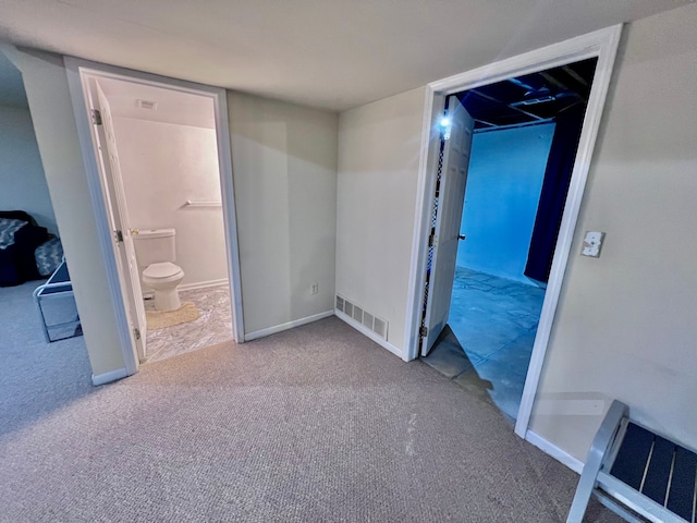 unfurnished bedroom with visible vents, baseboards, ensuite bathroom, and carpet flooring