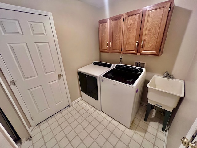 laundry room featuring a sink, cabinet space, and separate washer and dryer