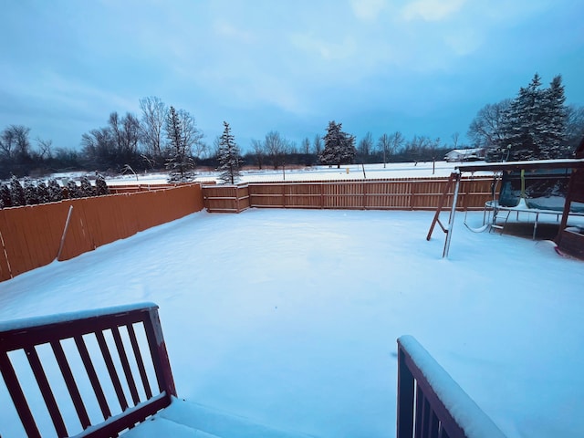 yard layered in snow featuring fence