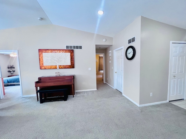 corridor with high vaulted ceiling, carpet, visible vents, and baseboards