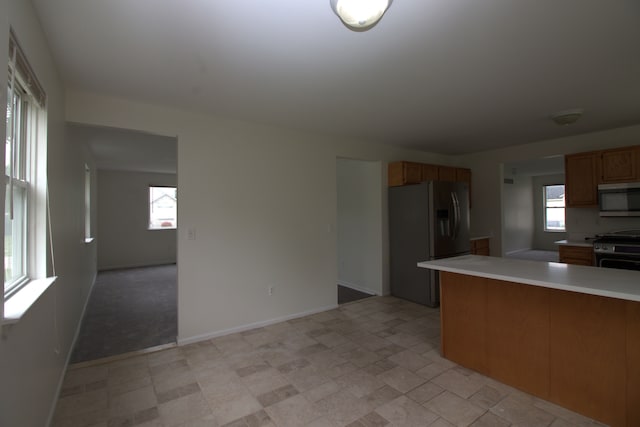 kitchen featuring a wealth of natural light, stainless steel appliances, and light countertops