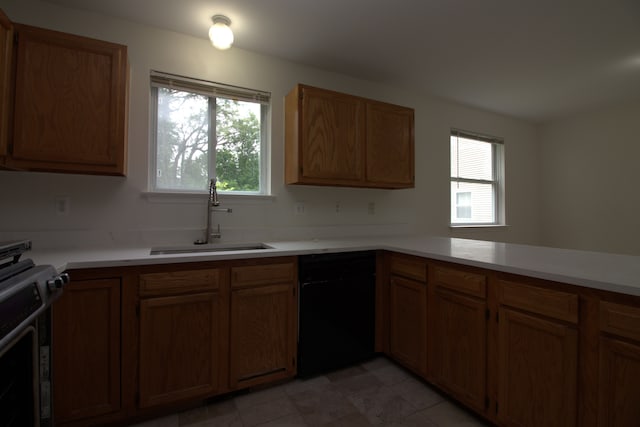 kitchen with brown cabinets, stainless steel range, a sink, light countertops, and dishwasher