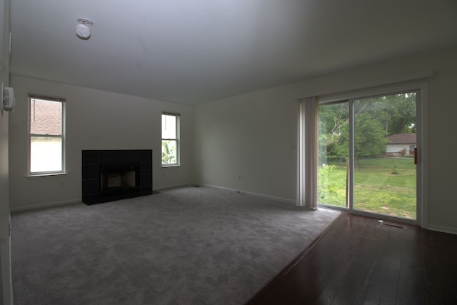 unfurnished living room featuring visible vents, a fireplace, baseboards, and carpet floors