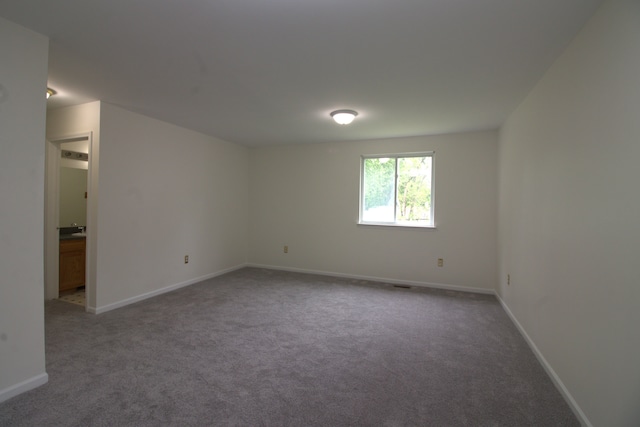 carpeted spare room featuring baseboards