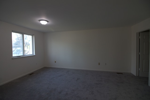 carpeted empty room featuring baseboards