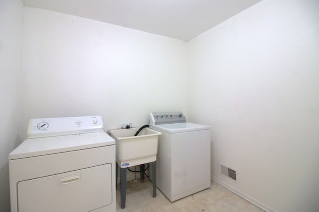 laundry area featuring visible vents, light floors, laundry area, and washer and clothes dryer