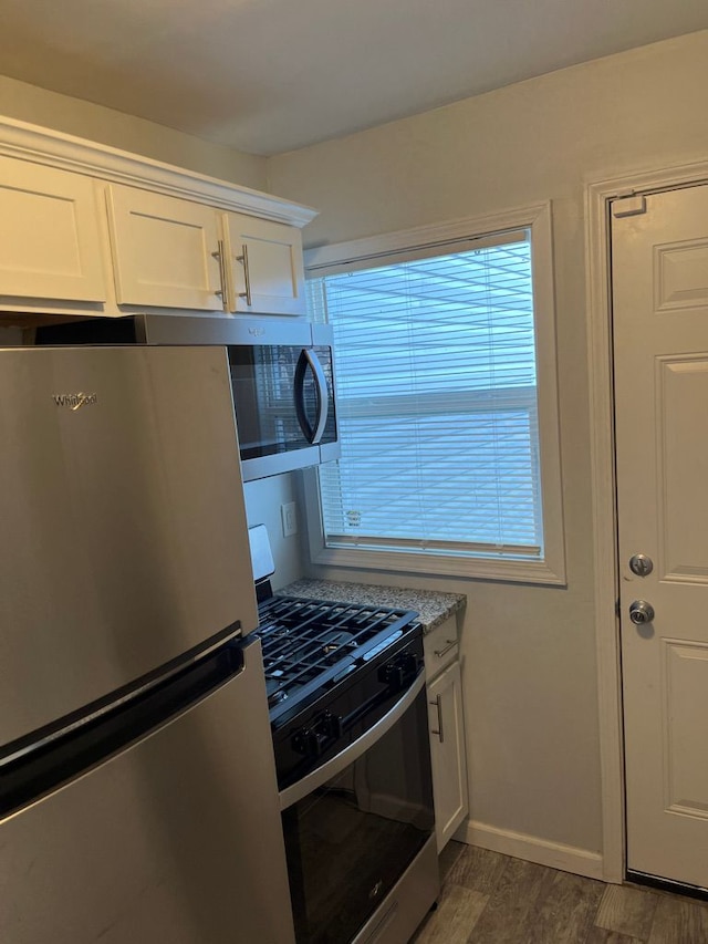 kitchen featuring baseboards, light countertops, appliances with stainless steel finishes, white cabinets, and dark wood-style flooring