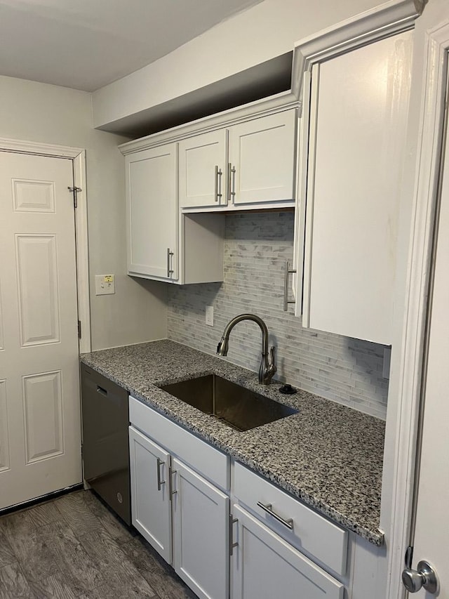 kitchen featuring dark wood finished floors, a sink, white cabinets, dishwasher, and tasteful backsplash