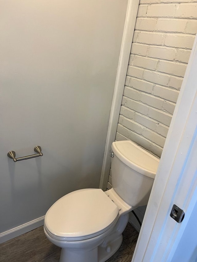 bathroom with baseboards, toilet, and wood finished floors