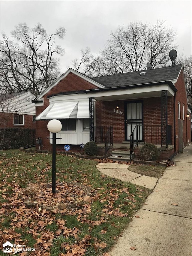 bungalow-style house featuring brick siding and a porch