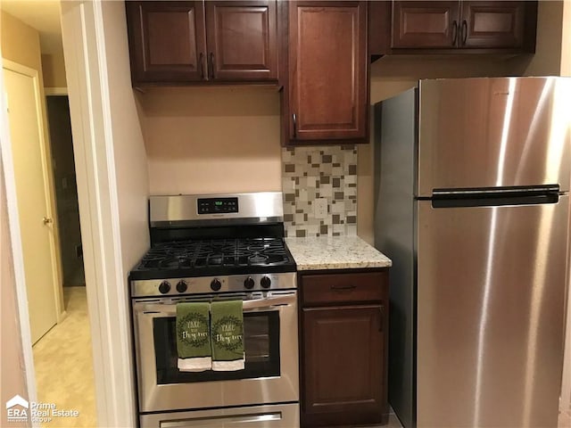 kitchen featuring light stone counters, decorative backsplash, dark brown cabinets, and appliances with stainless steel finishes