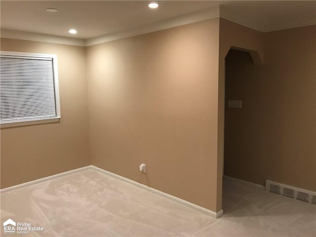 empty room featuring visible vents, carpet floors, baseboards, recessed lighting, and arched walkways