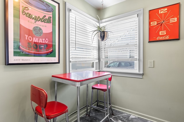 dining area featuring baseboards and marble finish floor