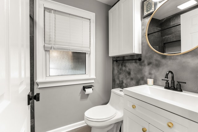 bathroom featuring vanity, toilet, and baseboards