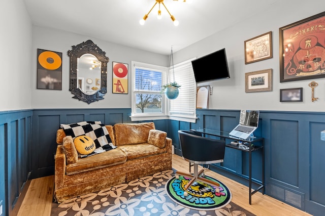 living room featuring visible vents, wainscoting, an inviting chandelier, and wood finished floors